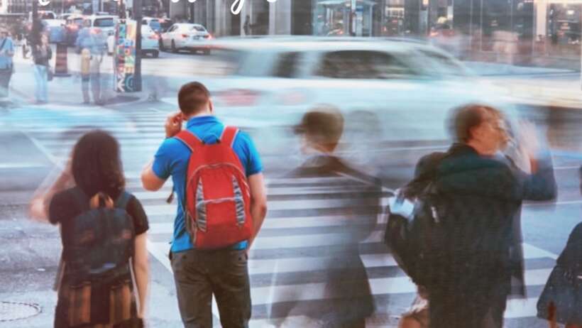 City street scene with pedestrians crossing, motion blur.