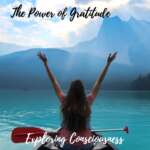 Woman canoeing on lake, arms raised in gratitude.