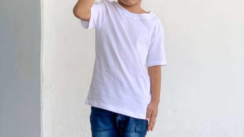 Boy in white tee saluting.